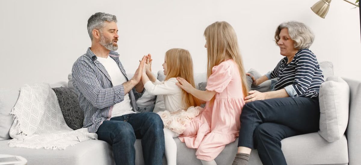 A joyful family spends quality time together, playing and bonding on a cozy sofa.