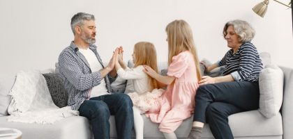 A joyful family spends quality time together, playing and bonding on a cozy sofa.