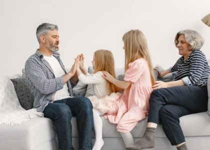 A joyful family spends quality time together, playing and bonding on a cozy sofa.